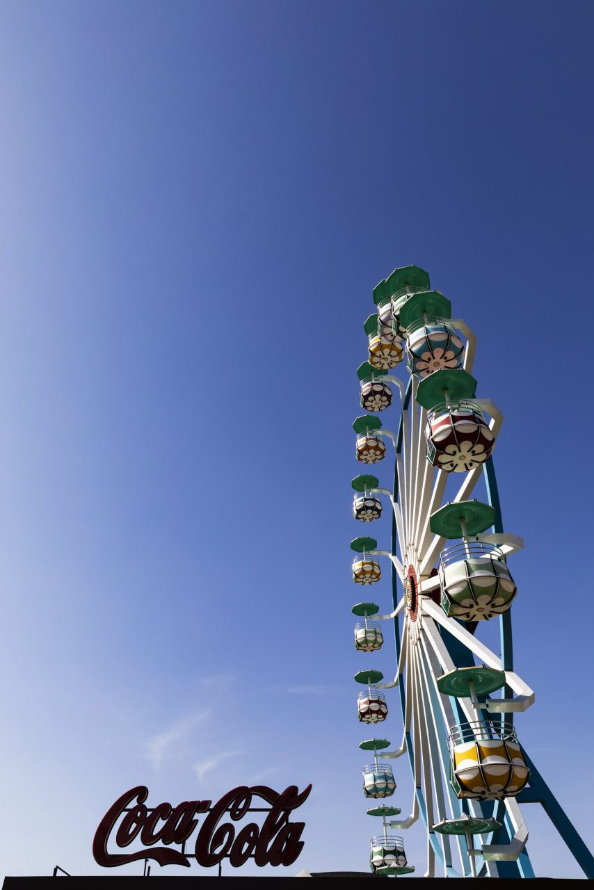 Grande roue vintage dans un parc d’attraction avec une enseigne Coca Cola
