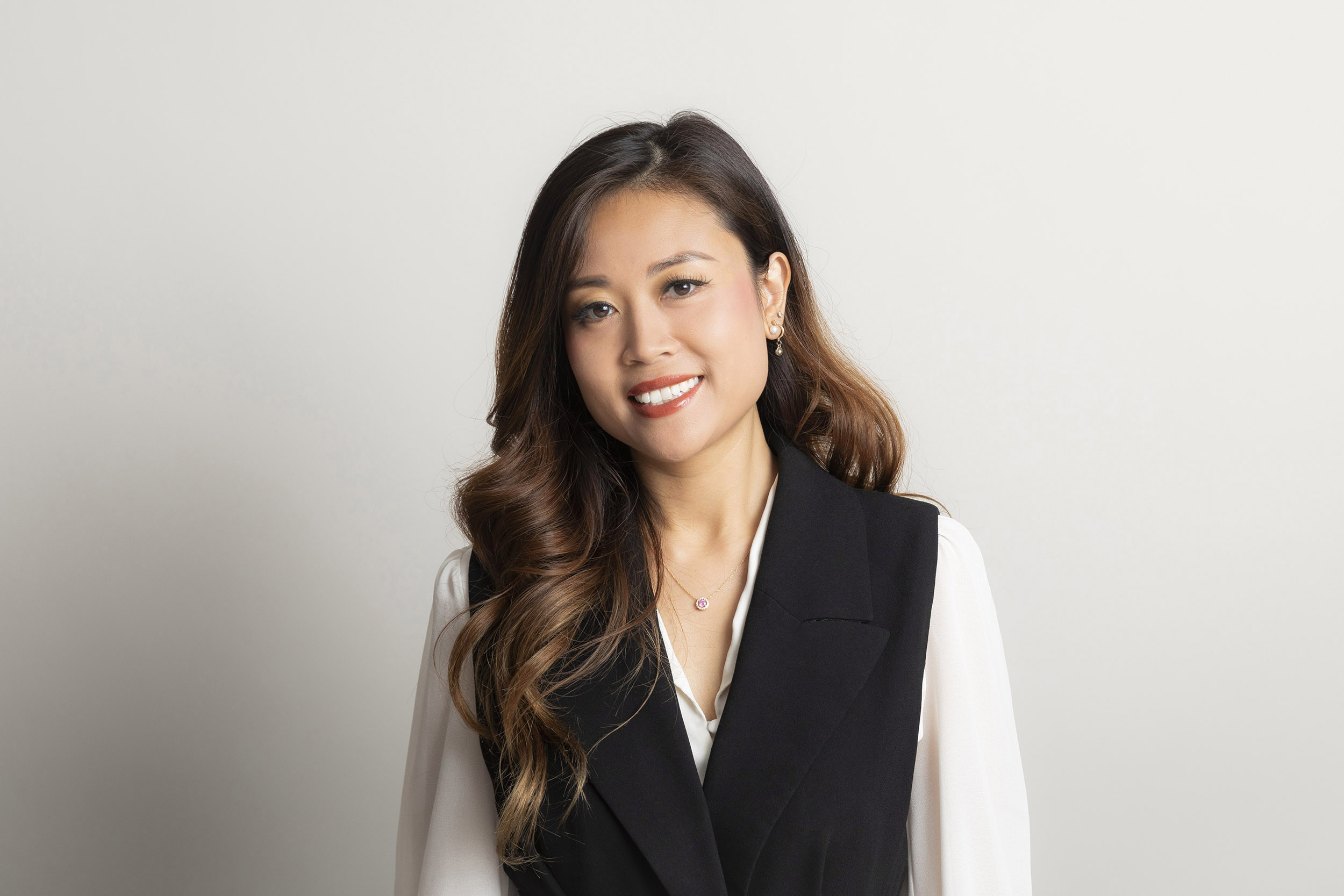 Portrait professionnel d'une femme en tenue de bureau réalisé par un photographe corporate en studio.